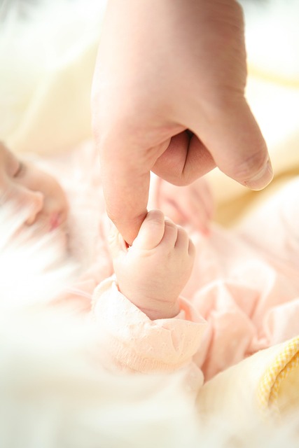 infant holding mothers finger
