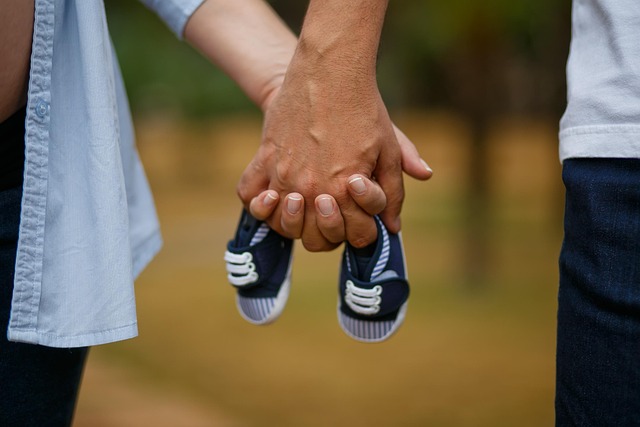 couple holding tiny baby shoes
