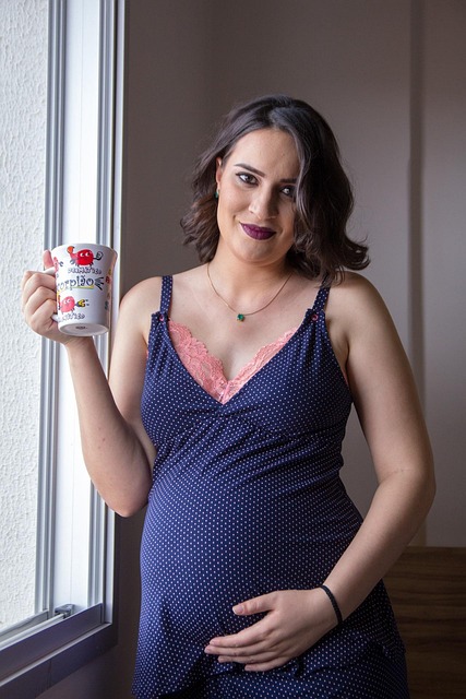 pregnant woman in blue dress with coffee mug