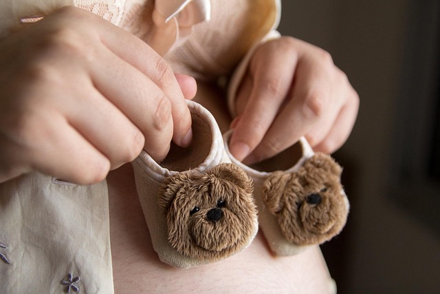 woman holding tiny baby shoes